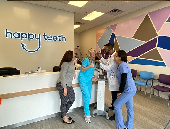 The Happy Teeth of Levittown dental team and dentist at the front desk