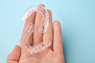 Close up of clear aligners in hand