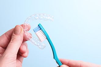 Patient cleaning clear aligner with toothbrush