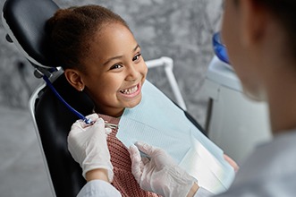 Child smiling at dentist during checkup