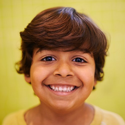 Child sharing healthy smile after pulp therapy